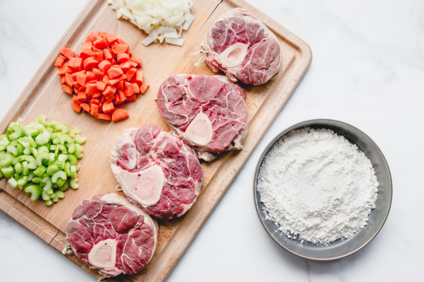 Beef Shank Osso Bucco raw beef shank on cutting board with bowl of flour and mirepoix