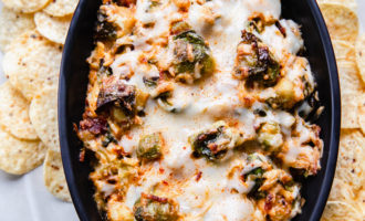 baked hot cheesy brussel sprout and bacon dip in staub