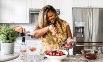 watermelon salad with berries and roasted beets, black woman making a salad in an Anthropologie dress